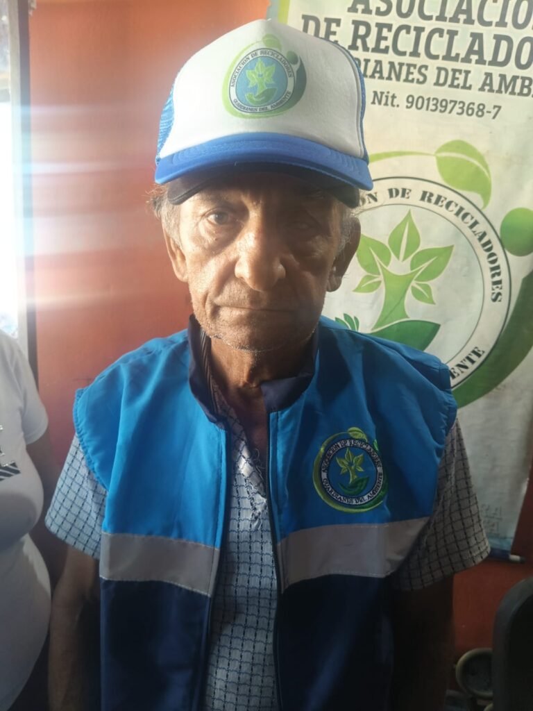 Asociado de la Asociación de Recicladores Guardianes del Ambiente uniformado con chaleco reflectivo azul